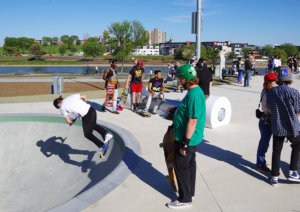 Skateboarders wait their turn to "drop-in" on one of the skateparks bowl features.